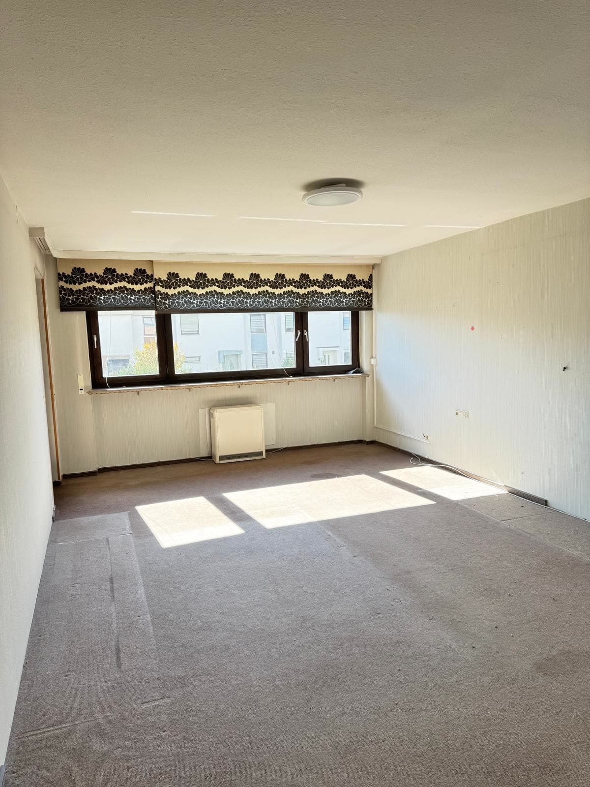 Dasselbe Wohnzimmer aus der anderen Ecke, leer und gefegt