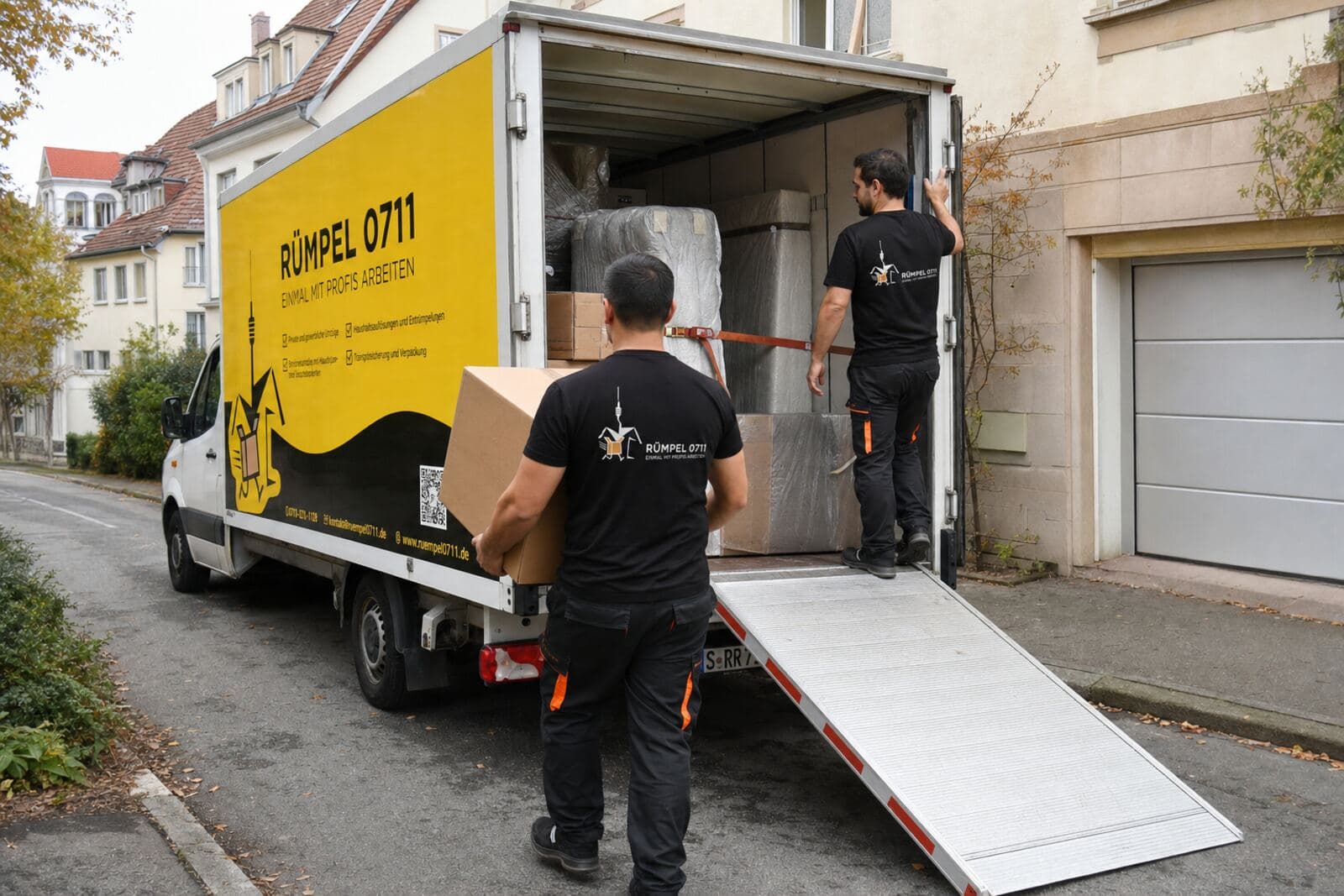 Umzug: Kartons werden über die Rampe in den Rümpel 0711 Transporter geladen