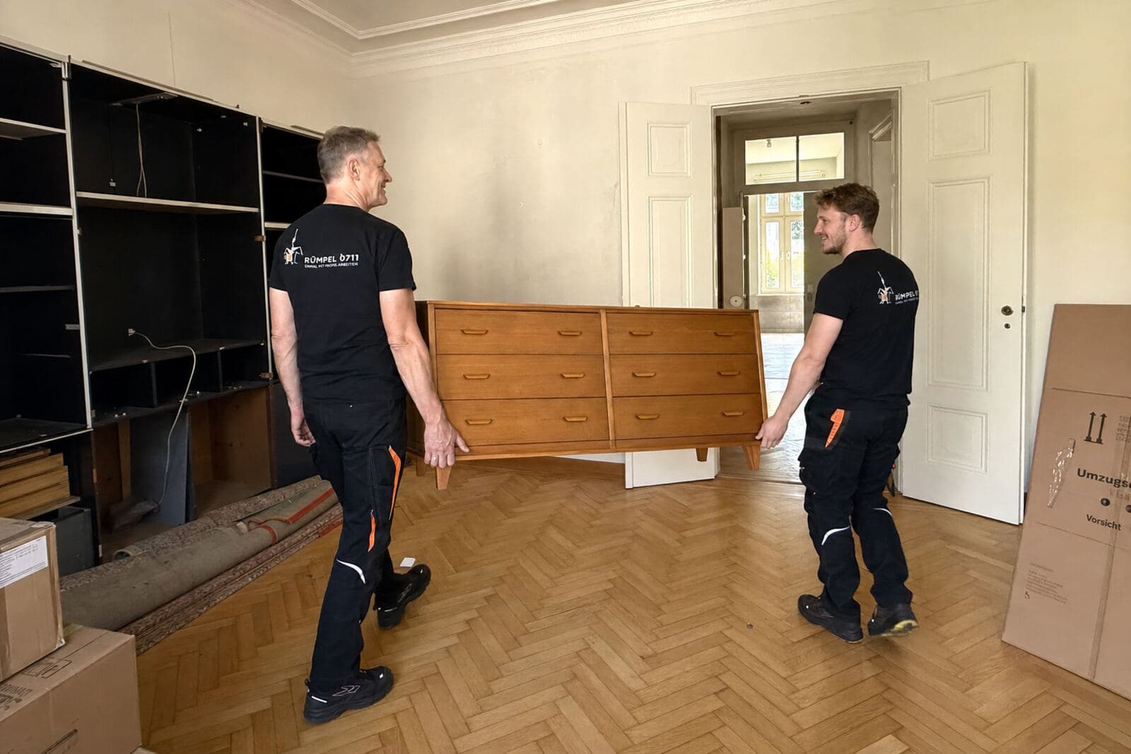 Wohnungsauflösung in einer Altbauwohnung, Möbel werden getragen